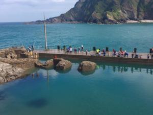 a group of people walking on a pier over the water at Apartment Horizons by Interhome in Ilfracombe