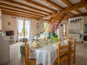 a dining room with a table and a kitchen at Holiday Home La Châtaigneraie by Interhome in Aubazines