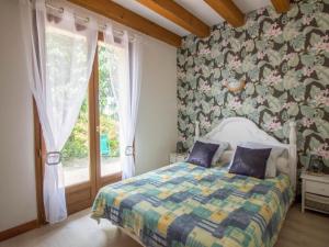 a bedroom with a bed and a large window at Holiday Home La Châtaigneraie by Interhome in Aubazines