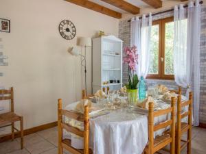 a dining room with a table and a clock on the wall at Holiday Home La Châtaigneraie by Interhome in Aubazines