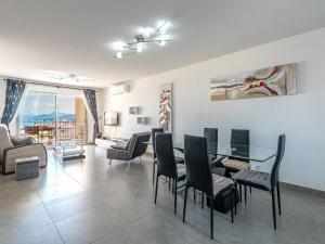 een woonkamer met een glazen tafel en stoelen bij Apartment Clos des Oliviers by Interhome in LʼÎle-Rousse
