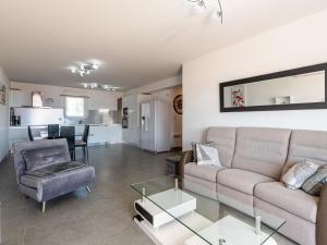 een woonkamer met een bank en een tafel bij Apartment Clos des Oliviers by Interhome in LʼÎle-Rousse