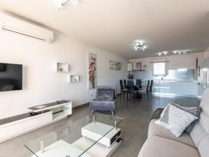 een woonkamer met een bank en een tafel bij Apartment Clos des Oliviers by Interhome in LʼÎle-Rousse