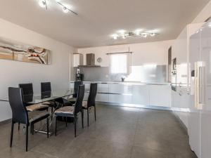 een keuken en eetkamer met een tafel en stoelen bij Apartment Clos des Oliviers by Interhome in LʼÎle-Rousse