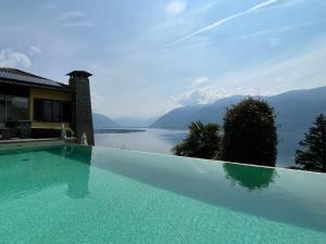 einen Pool mit Blick auf das Wasser in der Unterkunft Holiday Home Villetta Irma by Interhome in Ronco sopra Ascona