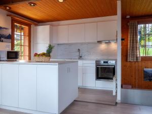 a kitchen with white appliances and a wooden ceiling at Chalet Petite Plaisance by Interhome in Nendaz