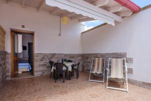 un patio con tavolo e sedie in camera di Mamba House 3 a Melendugno