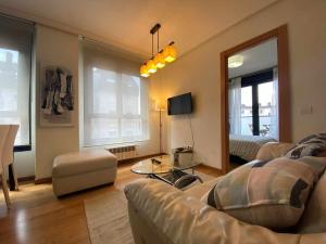 un soggiorno con 2 divani e uno specchio di Oviedo Soja City apartamento a minutos del centro a Oviedo