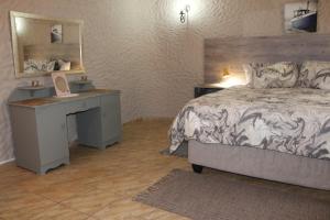 華維斯灣的住宿－Amjicaja Guesthouse, Tours & Rentals，一间卧室配有一张床、一张书桌和一面镜子