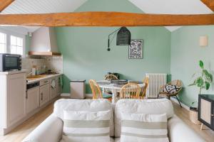 a kitchen with a table and chairs in a room at Ferme des Goupillières in Maisons