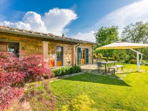 Casa de piedra con mesa y sombrilla en Holiday Home Casa 360 by Interhome, en Greve in Chianti
