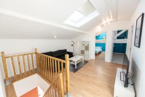 a loft apartment with a staircase and a living room at KASA DUPLEX - Climatisation - Balcon - Parking Privé in Rive-de-Gier