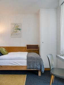 Chez Elsy - Crans-Sapins في كرانس مونتانا: غرفة نوم بسرير وكرسي