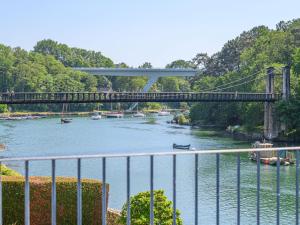 a bridge over a river with boats in the water at Holiday Home Glann Aven by Interhome in Le Bono