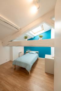 Rive-de-GierにあるKASA DUPLEX - Climatisation - Balcon - Parking Privéの青い壁のベッドルーム1室(ベッド1台付)