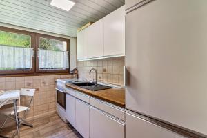 a kitchen with white cabinets and a refrigerator at Heidi Kimmig in Bad Griesbach