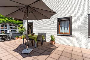 a table and chairs with an umbrella on a patio at Heidi Kimmig in Bad Griesbach
