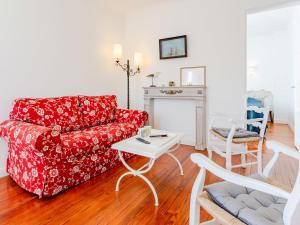 een woonkamer met een rode bank en een tafel bij Holiday Home Le Colibri by Interhome in Cabourg