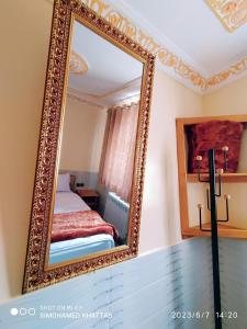 a mirror on a wall with a bed in a room at Chalets ITO Atlas Timnay in Midelt