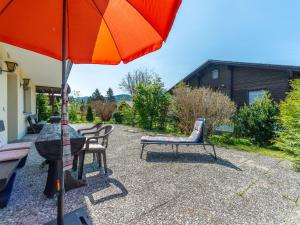 a patio with a table and chairs and an umbrella at Apartment Am Hohen Bogen-64 by Interhome in Kummersdorf