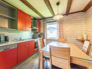 a kitchen with red cabinets and a table and chairs at Apartment Am Hohen Bogen-64 by Interhome in Kummersdorf