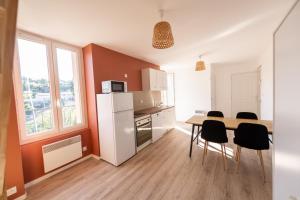 a kitchen with a table and chairs in a room at KASA DUPLEX - Climatisation - Balcon - Parking Privé in Rive-de-Gier