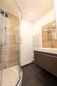 La salle de bains est pourvue d'une douche et d'un lavabo. dans l'établissement KASA DUPLEX - Climatisation - Balcon - Parking Privé, à Rive-de-Gier
