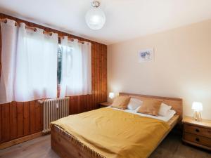 sypialnia z łóżkiem z żółtą pościelą i oknem w obiekcie Apartment Le Nerey-2 by Interhome w mieście Saint-Gervais-les-Bains