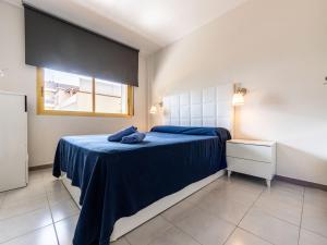 a bedroom with a bed with blue sheets and a window at Apartment Miramar Nautic by Interhome in Salou