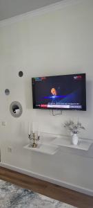 uma televisão numa parede acima de um lavatório branco em Апартаменты ЦО Радуга (шикарный вид) em Chon-Sary-Oy