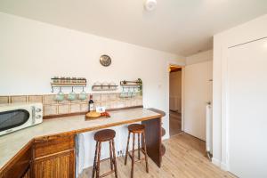 a kitchen with a counter and two stools at Bellrock View in Panbride