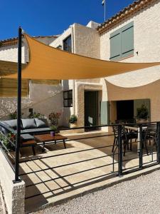 a patio with a table and a couch and a wooden table at La Ribasse en Provence in Venelles