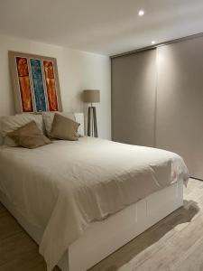 una camera da letto con un grande letto bianco con due dipinti sul muro di La Ribasse en Provence a Venelles