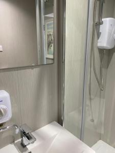 uma casa de banho com um chuveiro e um lavatório. em Marina Studio em Irvine