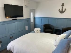 a bedroom with a large white bed with a flat screen tv at Marina Studio in Irvine