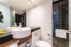 ein Bad mit einem Waschbecken, einem WC und einer Dusche in der Unterkunft Premier Inn Düsseldorf City Centre in Düsseldorf