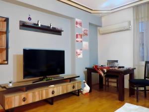 a living room with a flat screen tv and a table at Central and Serene Flat with Balcony in Antalya in Antalya