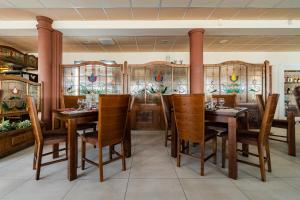 uma sala de jantar com mesas e cadeiras de madeira em Panoráma Hotel em Békéscsaba