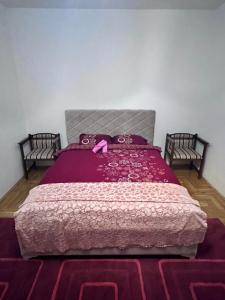 um quarto com uma cama com um edredão rosa em Luxury House em Bijelo Polje