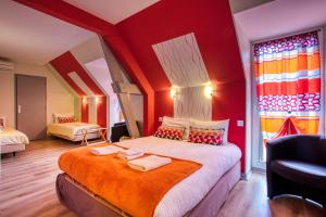 a bedroom with a large bed with red walls at Hôtel A Jayac - Logis Hotels in Laval