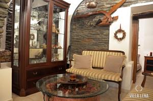 a living room with a couch and a glass table at VILLA LENA - ΑΝΔΡΟΣ in Batsi