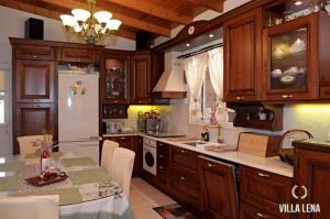 a kitchen with wooden cabinets and a white refrigerator at VILLA LENA - ΑΝΔΡΟΣ in Batsi