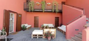 um pátio com um edifício cor-de-rosa com bancos e plantas em Il Casale di Giulia di Aprilia em Aprilia