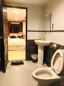 a bathroom with a toilet and a sink and a bed at Benetti house in Patong Beach