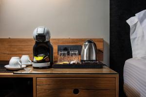 a coffee maker on a table next to a bed at Angelica's Deluxe Rooms in Adamas in Adamas