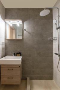 La salle de bains est pourvue d'un lavabo et d'une douche avec un miroir. dans l'établissement Fotoula's stone studio, 