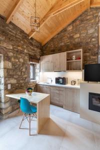 - une cuisine avec des murs en bois, une table et des chaises dans l'établissement Fotoula's stone studio, 