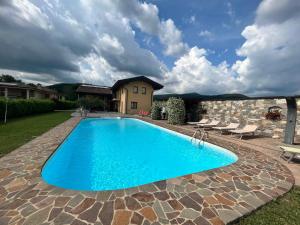 a swimming pool in a yard with chairs and a house at Agriturismo e Alloggi Luis Gianni in Cividale del Friuli