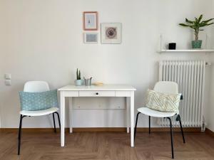 un escritorio blanco y 2 sillas en una habitación en Urban Retreat: 1-bedroom with terrace in Goudi, en Atenas