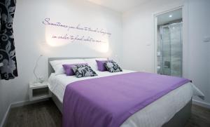 a bedroom with a large bed with purple sheets at Apartment 4 You in Split in Split